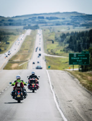 MotMotorcyclist with the open road in front of them and mountains in the foreground