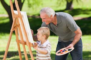 Grandfather and grandson painting outside