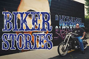 A biker sitting on his bike in front of an Elvis Presley mural