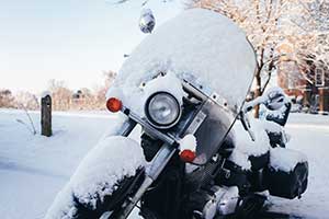 Motorcycle parked outside and covered in snow