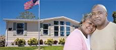 A couple hugging with manufactured home behind them