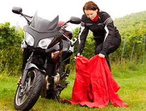A motorcyclist putting on rain gear