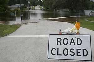 A Road Closed sign in front of flooded street