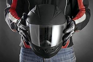 A biker holding a protective helmet
